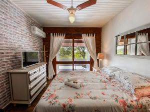 a bedroom with a large bed and a television at Morada das Bromélias in Torres +61 photos