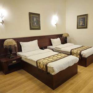 a hotel room with two beds and two lamps at Khani Hotel in Duhok