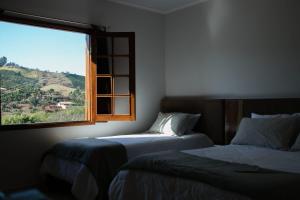 1 dormitorio con 2 camas y ventana en Hotel Manoah en Socorro