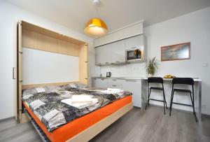 ein Schlafzimmer mit einem Bett und eine Küche mit einem Tisch in der Unterkunft Appartment Waltrovka, free parking in Prag