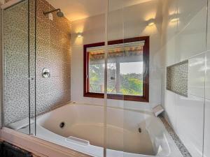 baño con bañera y ventana en Morada das Bromélias, en Torres