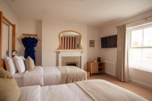 a bedroom with two beds and a fireplace and a mirror at Lido Townhouse in Bristol