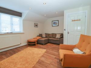 a living room with a couch and a chair at Y Enciliad in Rhosneigr
