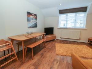 a dining room with a table and a tv at Y Enciliad in Rhosneigr