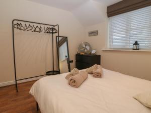 a bedroom with a bed with towels on it at Y Enciliad in Rhosneigr