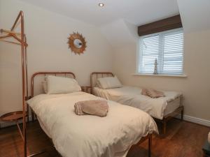 two beds in a room with a mirror on the wall at Y Enciliad in Rhosneigr