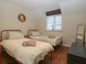 two beds in a room with a mirror on the wall at Y Enciliad in Rhosneigr