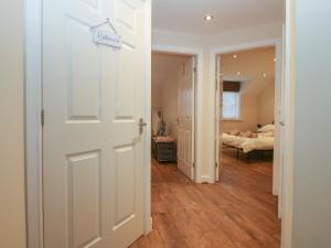 a white door leading to a bedroom with a bed at Y Enciliad in Rhosneigr