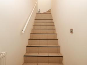 a staircase in a house with brown tiles at Y Enciliad in Rhosneigr