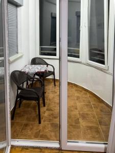 einen Balkon mit einem Tisch, Stühlen und Fenstern in der Unterkunft Apartment Kjara in Ohrid
