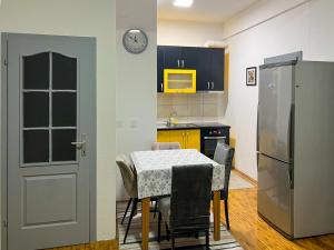 eine Küche mit einem Tisch mit Stühlen und einem Kühlschrank in der Unterkunft Apartment Kjara in Ohrid