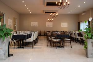 カリロにあるHoward Johnson Hotel & Convention Center Madariaga - Cariloのテーブルと椅子とシャンデリアのあるダイニングルーム