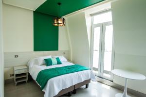 a bedroom with a bed with a green accent wall at Casa Esmeralda in Valparaíso