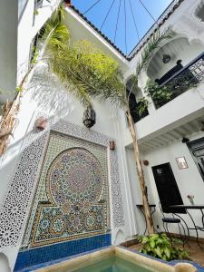 un mosaico en el lateral de una casa con una palmera en Dar Fangui, en Marrakech