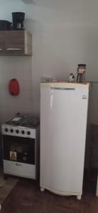 a kitchen with a stove and a white refrigerator at Apt para carnaval em Salvador in Salvador