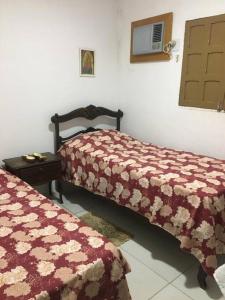ein Schlafzimmer mit zwei Betten und einem Tisch und einem Fenster in der Unterkunft Casa à beira mar com piscina em Itamaracá in Itamaracá + 52 Fotos