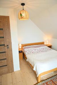 een slaapkamer met een bed en een houten vloer bij Chatka Beatki in Stryszawa