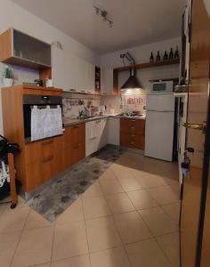 een keuken met houten kasten en een witte koelkast bij Appartamento Bellaria-Igea Marina con terrazza in Bellaria-Igea Marina