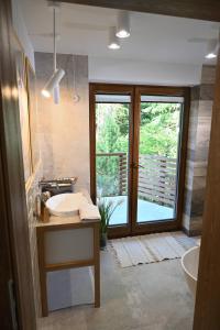 een badkamer met een wastafel, een bad en een raam bij Chatka Beatki in Stryszawa
