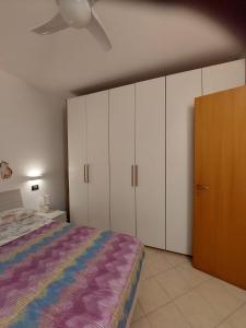 een slaapkamer met een bed, witte kasten en een plafond bij Appartamento Bellaria-Igea Marina con terrazza in Bellaria-Igea Marina