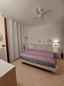 een slaapkamer met een bed en een plafondventilator bij Appartamento Bellaria-Igea Marina con terrazza in Bellaria-Igea Marina