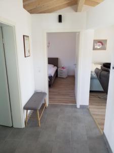 un pasillo con una habitación con cama y silla en Ferienwohnung Füssel - NICHT FÜR MONTEURE, en Bad Staffelstein