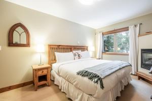 una camera con un grande letto e un camino di Spruce Grove Chalet by Outpost Whistler a Whistler