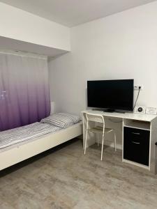 a bedroom with a desk and a tv and a bed at Alt Ap in Wuppertal