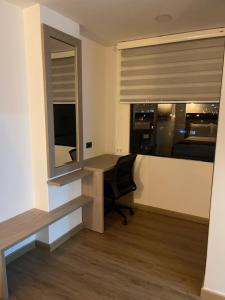 Zimmer mit einem Schreibtisch und einem Fenster mit einem Stuhl in der Unterkunft HOTEL SALVATORE in Paipa