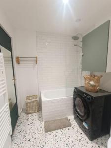 een badkamer met een bad en een wasmachine bij Studio centre Cauterets in Cauterets