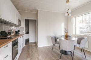 Una cocina con una mesa y sillas en una habitación. en Lakeview retreat in Pispala, en Tampere