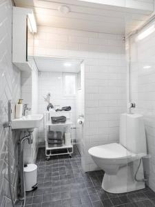 Un baño blanco con inodoro y lavabo. en Lakeview retreat in Pispala, en Tampere