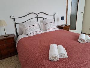 Un dormitorio con una cama con toallas blancas. en Casa Barbara en Corsico