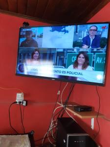 a flat screen tv hanging on a red wall at Maima Host II in Maimará