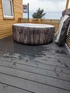 a large tire sitting on a wooden deck at Tracey’s Hideaway - with hot tub & amazing views in Llanasa