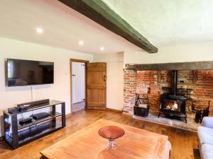 a living room with a fireplace and a brick wall at Bakehouse Farm in Princes Risborough