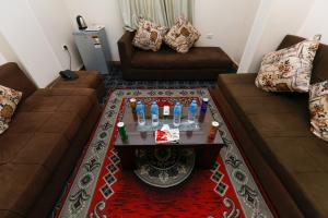 een woonkamer met 2 banken en een tafel met drankjes bij Giza Pyramids Inn in Caïro
