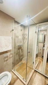 a bathroom with a glass shower with a toilet at Appartement spacieux, très calme in Casablanca