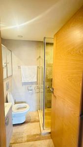a bathroom with a toilet and a glass shower at Appartement spacieux, très calme in Casablanca