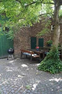 ein Picknicktisch und eine Bank neben einem Baum in der Unterkunft Hof am Rhein in Köln