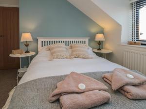 a bedroom with a white bed with towels on it at Barn Cottage in Saltburn-by-the-Sea