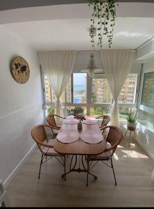 ein Esszimmer mit einem Tisch, Stühlen und einem Fenster in der Unterkunft Casa Rosa in Algarrobo-Costa