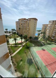 an aerial view of a tennis court with palm trees and buildings at Casa Rosa in Algarrobo-Costa