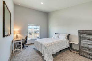 a bedroom with a bed and a desk and a window at Convenient Great Falls Condo Less Than 1 Mi to Shops! in Great Falls