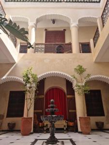 un patio con una fuente en el medio de un edificio en Labigarade riad, en Marrakech