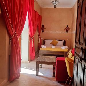 1 dormitorio con 1 cama con cortinas rojas en Labigarade riad, en Marrakech