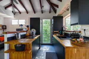 a kitchen with black cabinets and wooden counter tops at Villa Bwacajou in Beaurenom