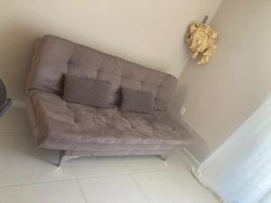 1 sofá marrón con 2 almohadas en la sala de estar en Apartamento margem do rio São Francisco en Paulo Afonso