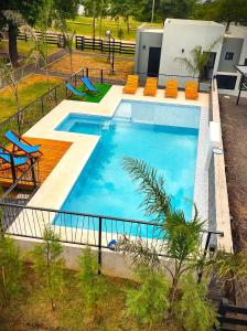 una vista aérea de una piscina con sillas naranjas en Cabañas Posta Litoral en Colón