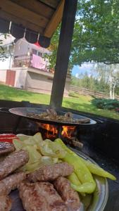 une plaque de viande et de légumes sur un grill dans l'établissement Forest Home, à Pale